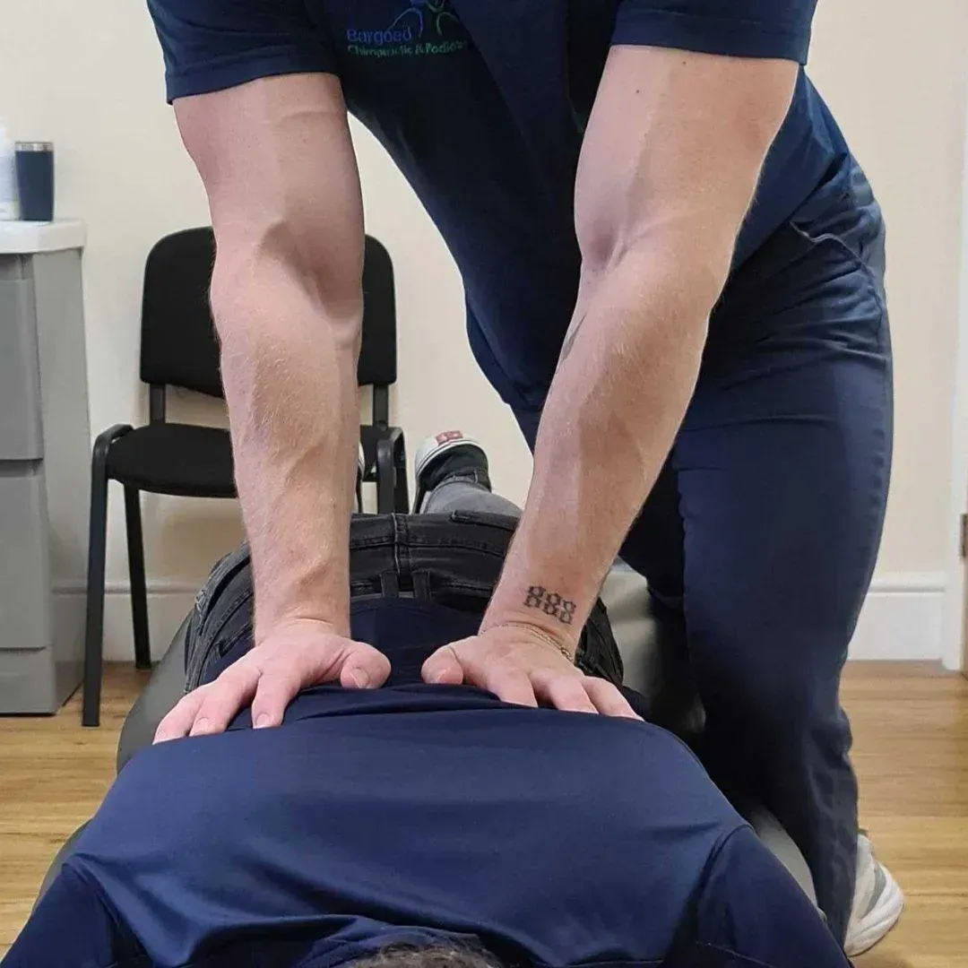 Chiropractor adjusting a patient's lower back with both hands