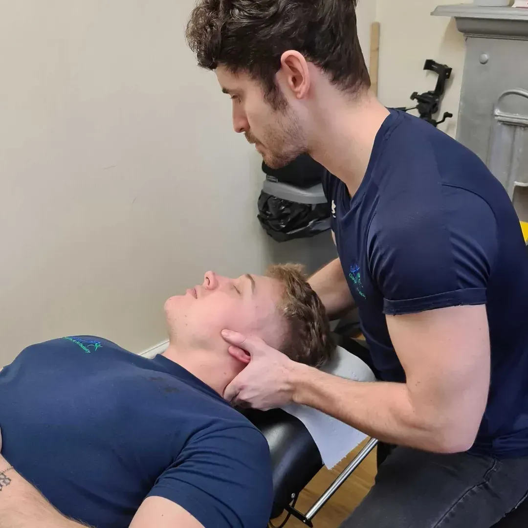 Chiropractor gently positioning a patient's neck before a cervical adjustment