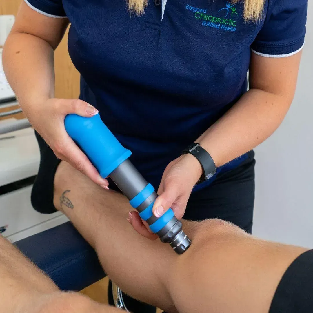 Shockwave therapy applicator being used on a patient's knee