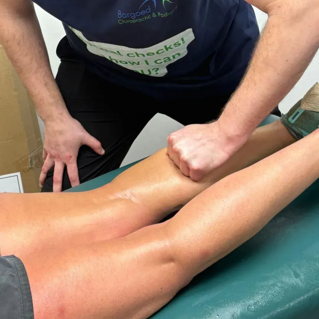 Sports massage therapist working on a patient's leg